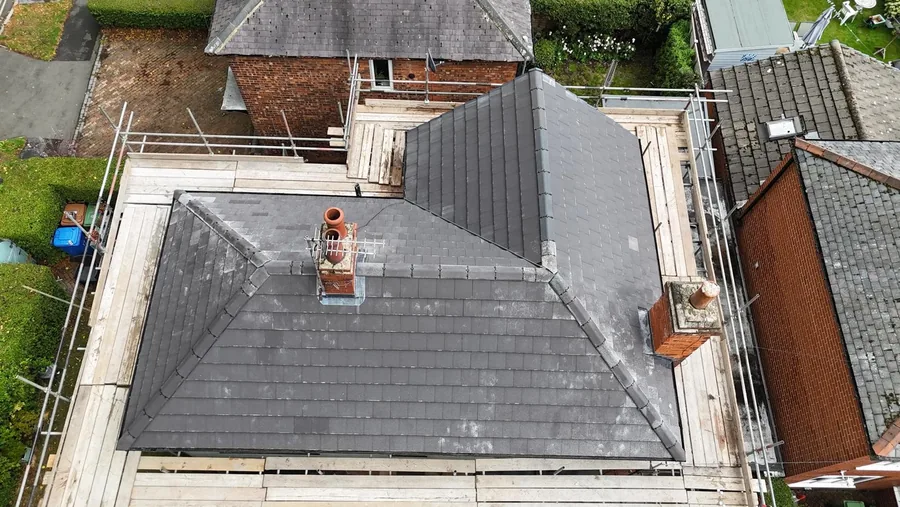 Aerial view of a Beverley hipped re-roof in grey tiles with repointed chimney stacks and scaffold