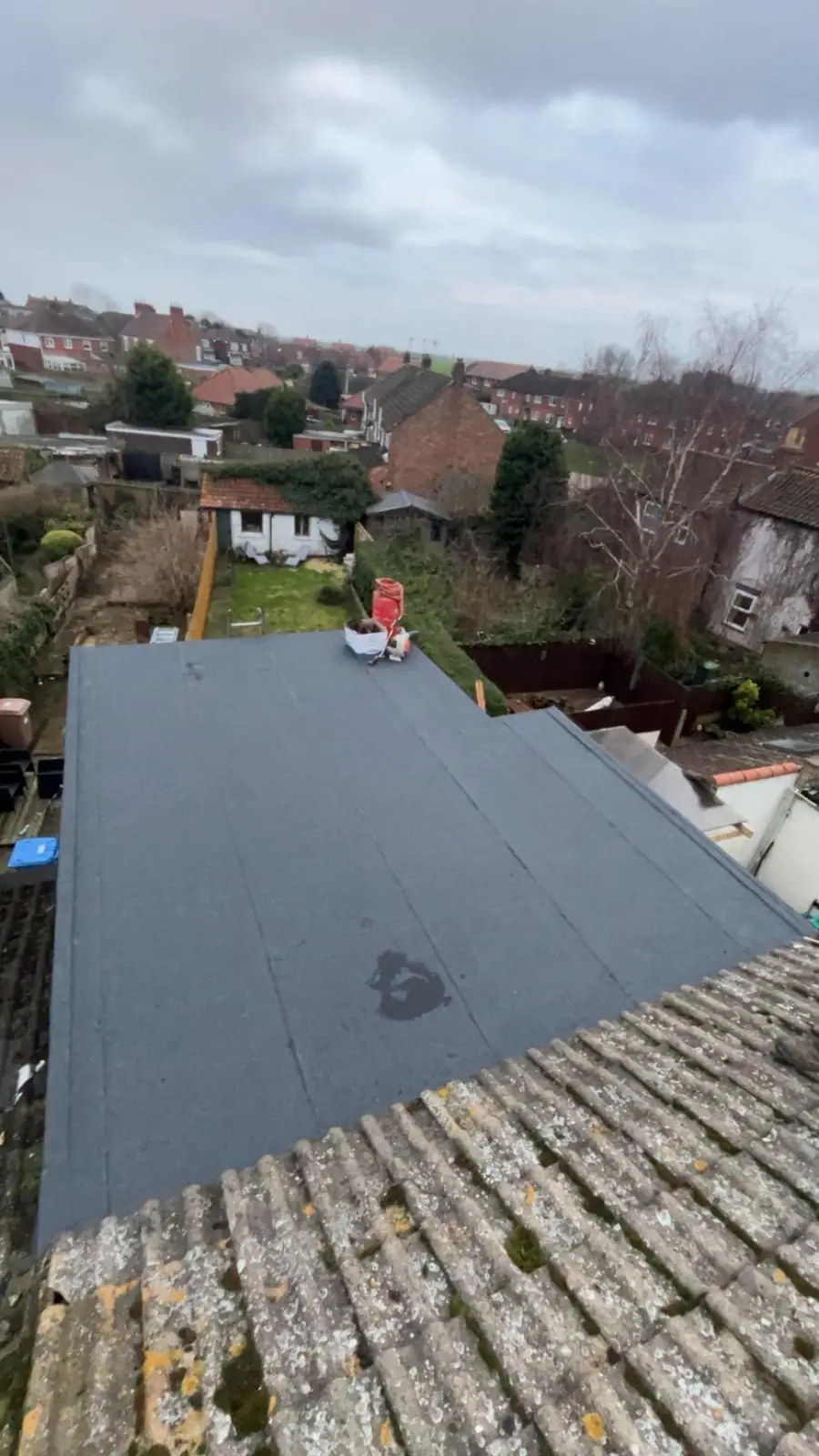 Flat roof laid over a garage with a gable end beyond
