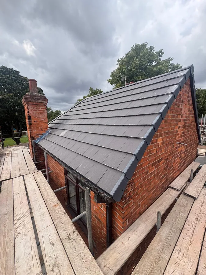 Grey flat tile roof and dry verge on the red brick gable end of a Beverley property