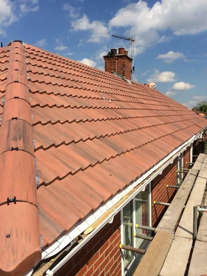 New terracotta pantile bungalow roof with white fascia and guttering at the eaves, scaffold in place