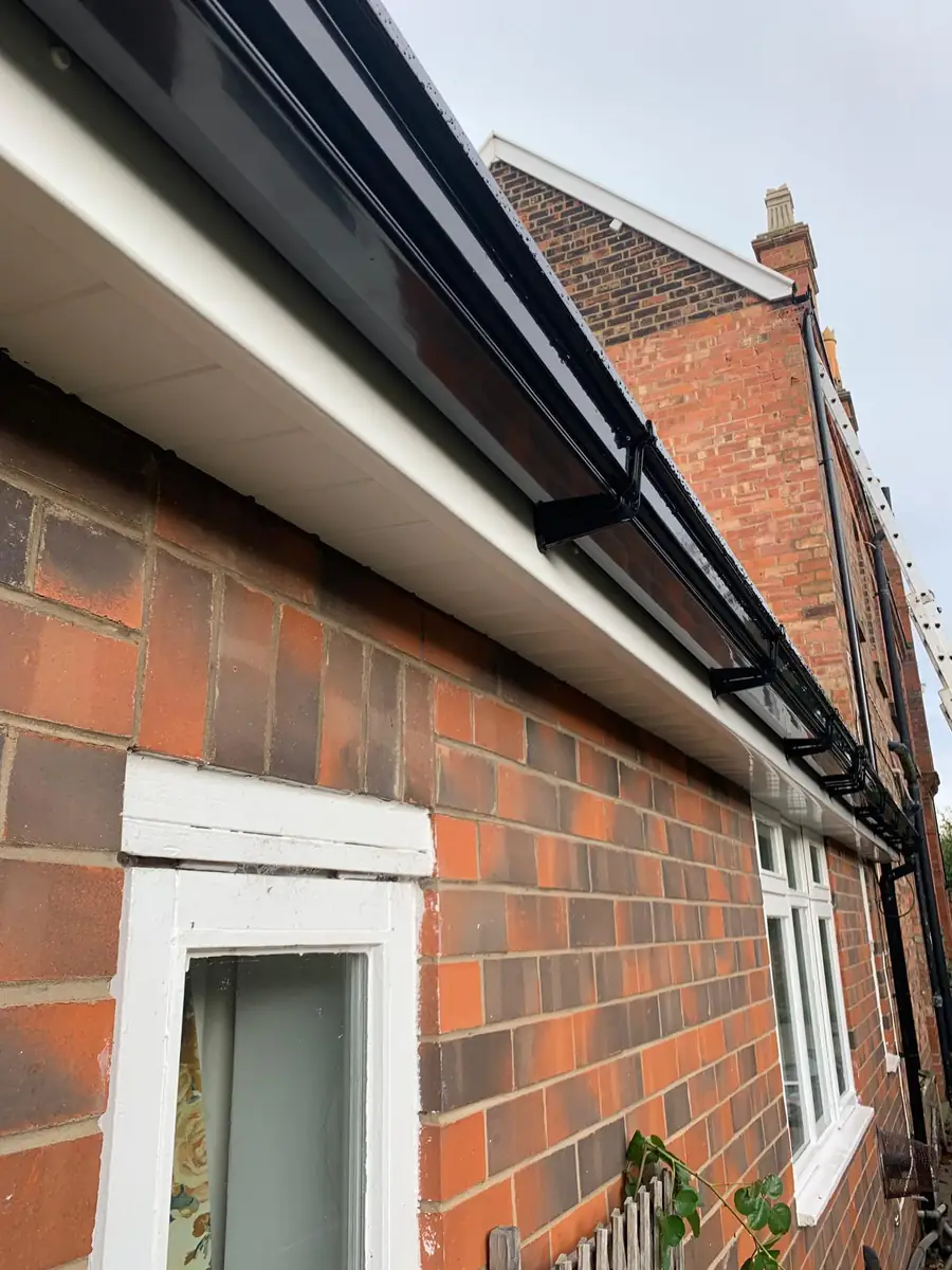 White uPVC soffit with black half-round guttering along a brick bungalow